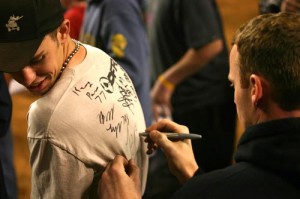 Tim Farr signs the back of a Phoenix fan's shirt. 