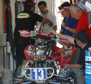 Here Natalie’s Pit Crew, led by Dee Manshack, franticly works on the 13 machine just before the second moto.