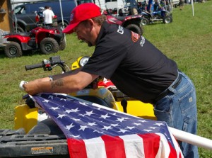 NE ATV-MX President, Howard Payne proudly prepairs American flags for flight along pit lane. 